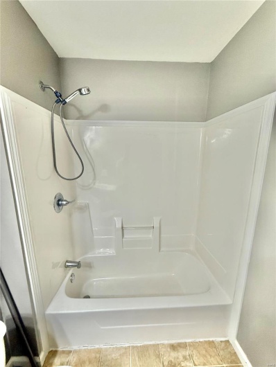 Bathroom with tile patterned floors and bathtub / shower combination