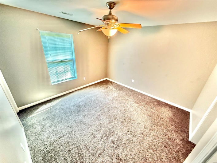 Carpeted empty room featuring ceiling fan, baseboards, and visible vents
