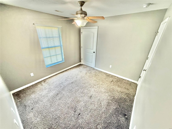 Unfurnished bedroom with ceiling fan, baseboards, visible vents, and carpet