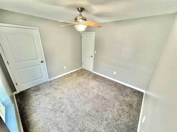 Unfurnished bedroom with carpet floors, baseboards, and ceiling fan