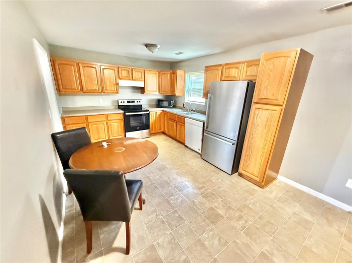 Kitchen featuring stainless steel appliances, a sink, visible vents, light countertops, and under cabinet range hood