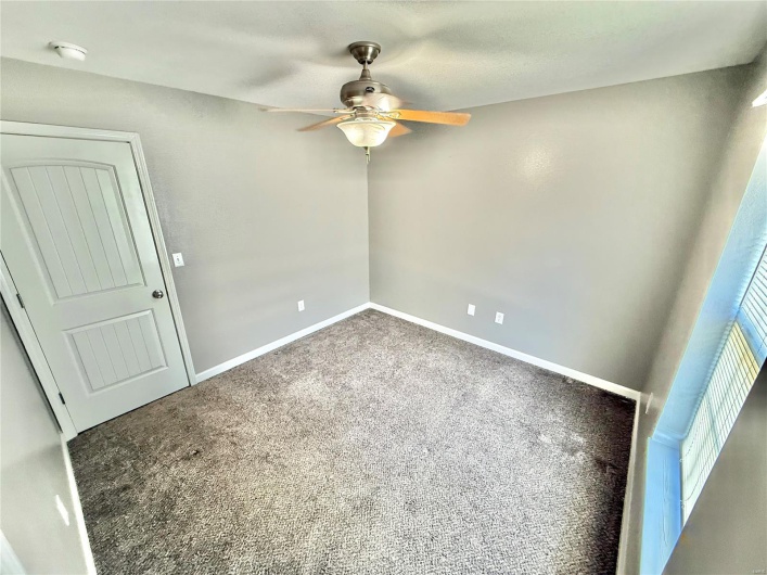 Empty room with ceiling fan, baseboards, and carpet