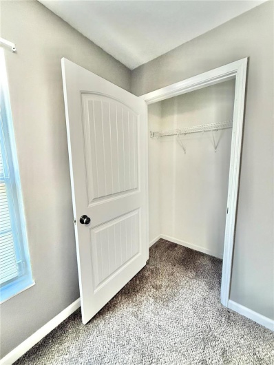Unfurnished bedroom featuring baseboards, carpet flooring, a closet, and multiple windows