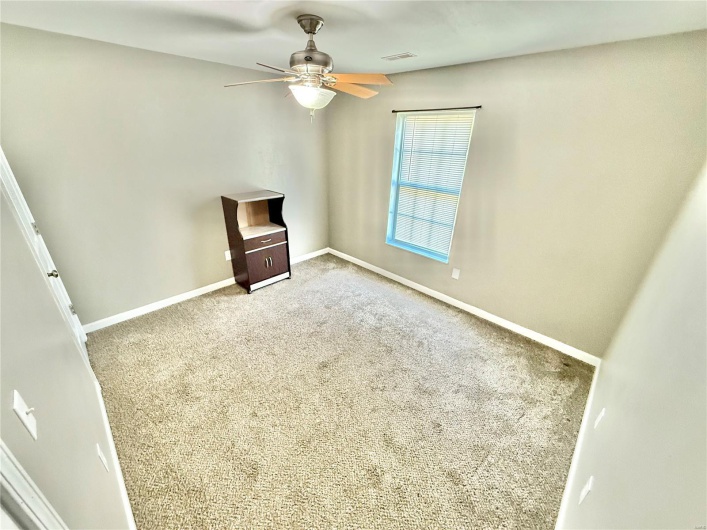 Unfurnished living room with ceiling fan, baseboards, visible vents, and carpet