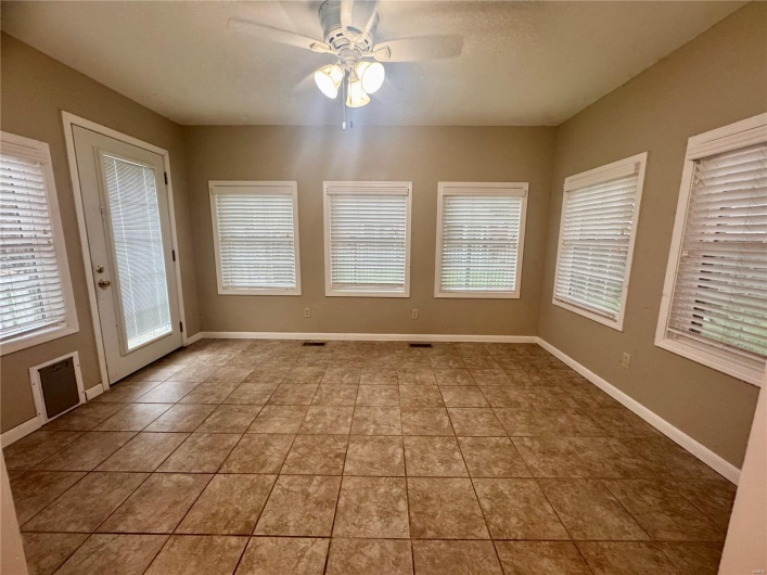 Tiled empty room with baseboards and ceiling fan