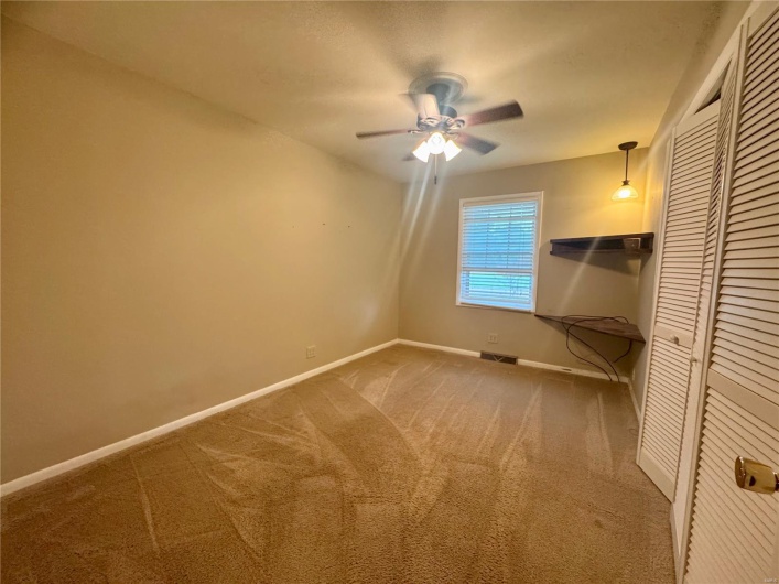 Unfurnished bedroom featuring ceiling fan, carpet, baseboards, visible vents, and a closet