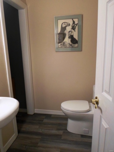 Half bath featuring toilet, wood finished floors, and baseboards