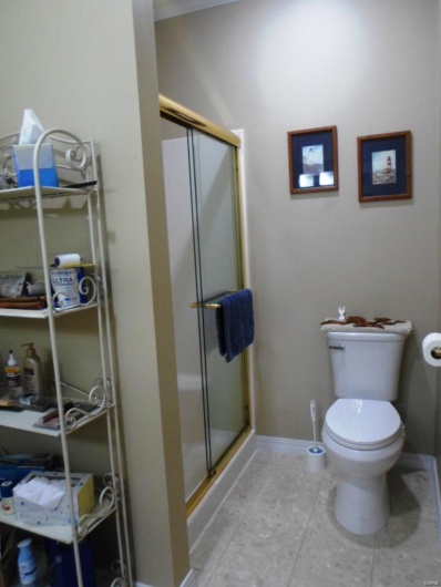Full bathroom with baseboards, toilet, and a stall shower