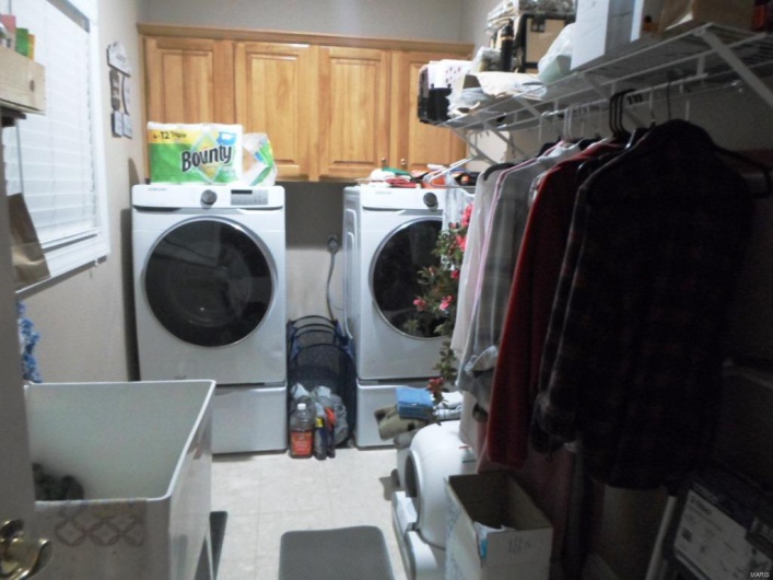 Laundry area with cabinet space, light tile patterned floors, and separate washer and dryer