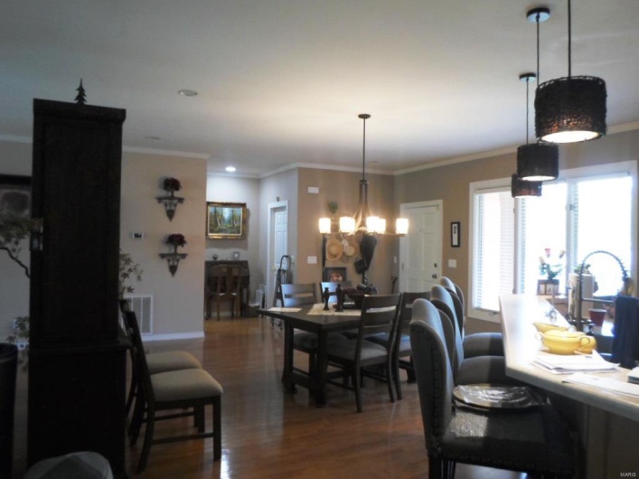 Dining area featuring an inviting chandelier, crown molding, wood finished floors, and baseboards