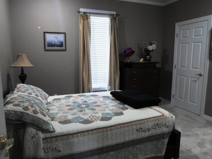 Carpeted bedroom with baseboards and crown molding