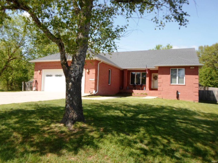 Single story home with a garage, brick siding, a front lawn, and concrete driveway