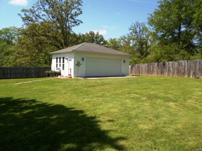 View of yard featuring a detached garage and a fenced backyard