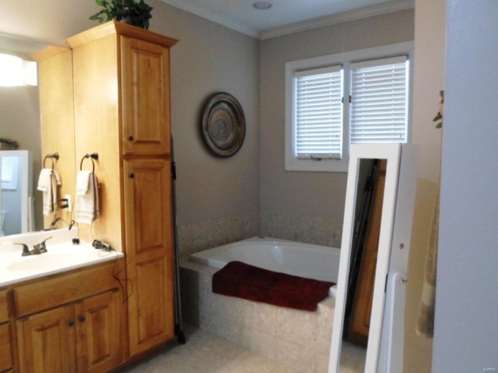Full bathroom with a bath, vanity, and ornamental molding