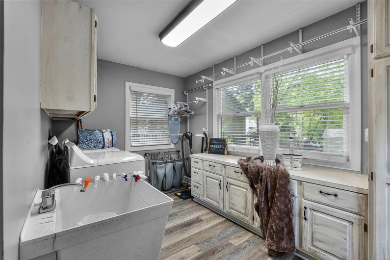 Washroom featuring washer / dryer, a sink, and light wood finished floors