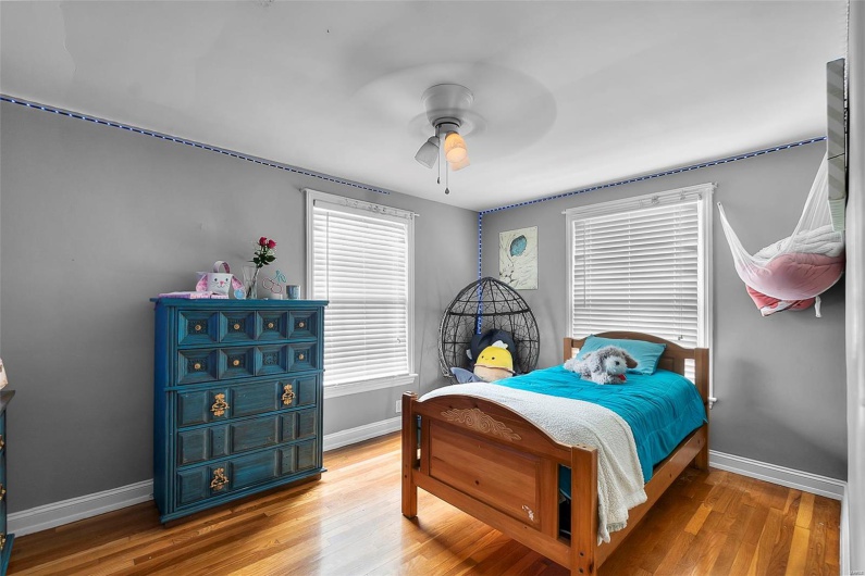 Bedroom featuring baseboards, a ceiling fan, and wood finished floors