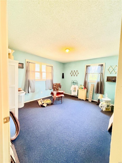 Recreation room with a textured ceiling and carpet