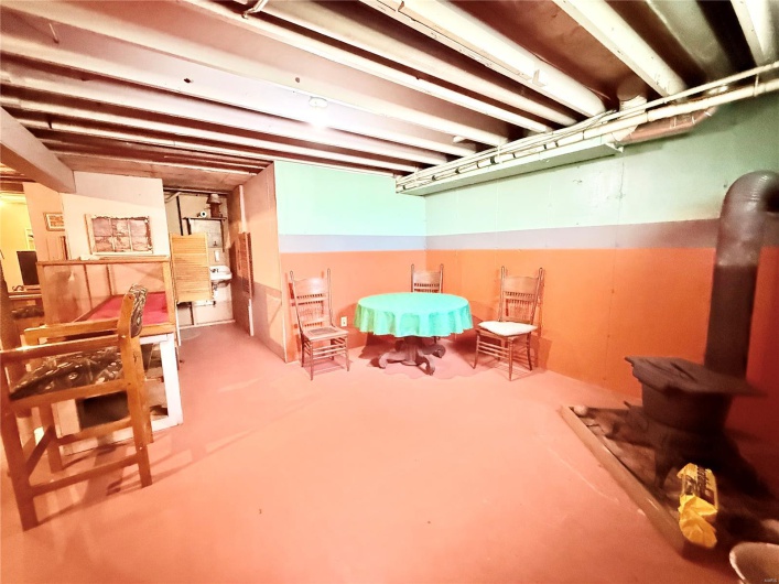 Unfinished below grade area featuring a wood stove