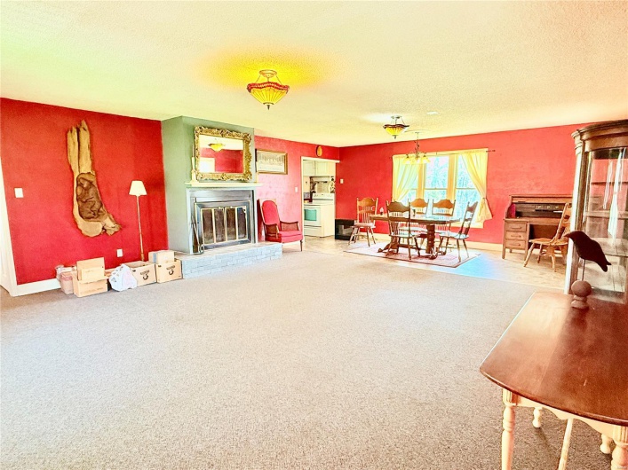 Living room with baseboards, a glass covered fireplace, carpet, and a textured ceiling