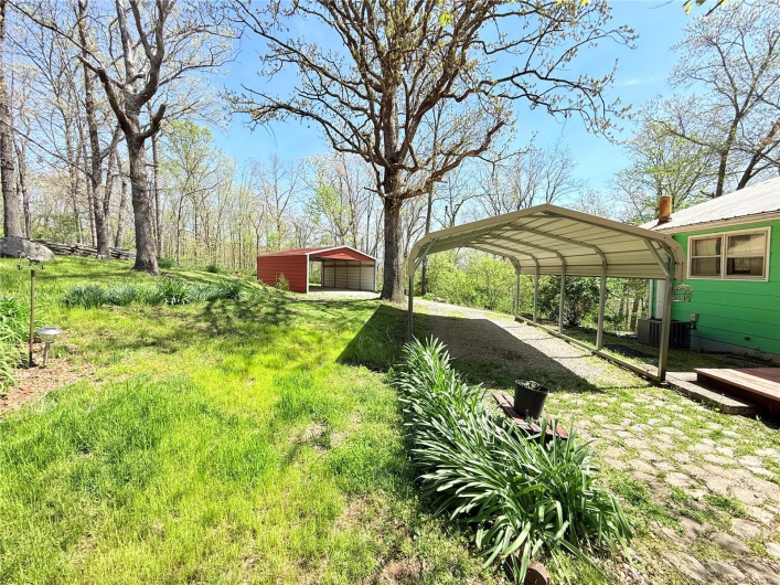 View of yard with driveway, a carport, and cooling unit