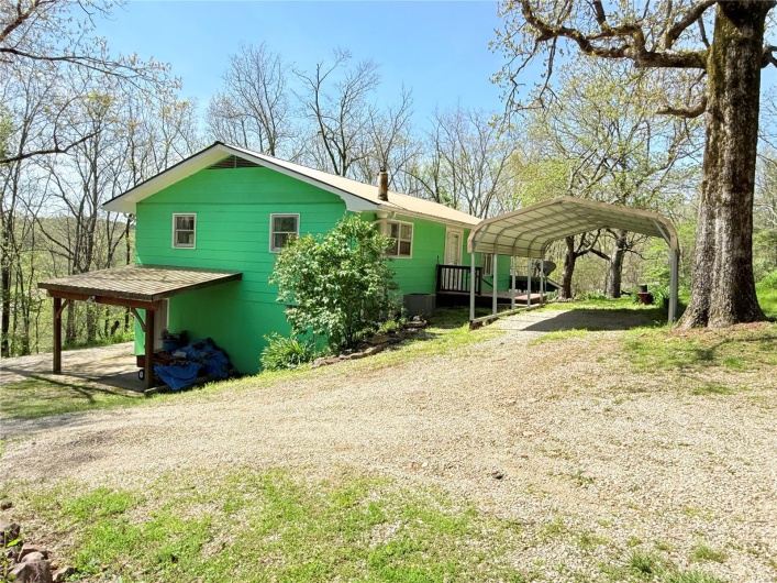 View of side of property with a carport and driveway