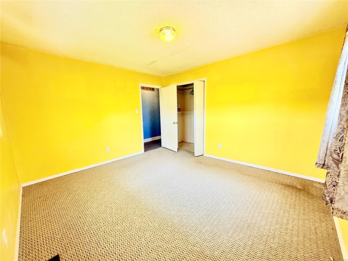 Unfurnished bedroom featuring baseboards, a closet, and light colored carpet