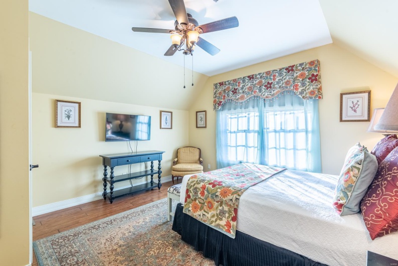 Bedroom featuring hardwood / wood-style flooring, ceiling fan, and lofted ceiling