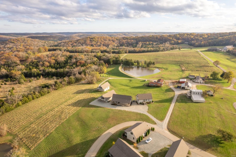 Birds eye view of property with a water view and a rural view