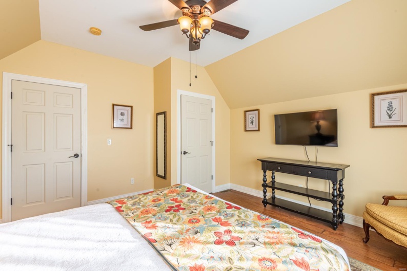 Bedroom featuring ceiling fan, hardwood / wood-style floors, and lofted ceiling