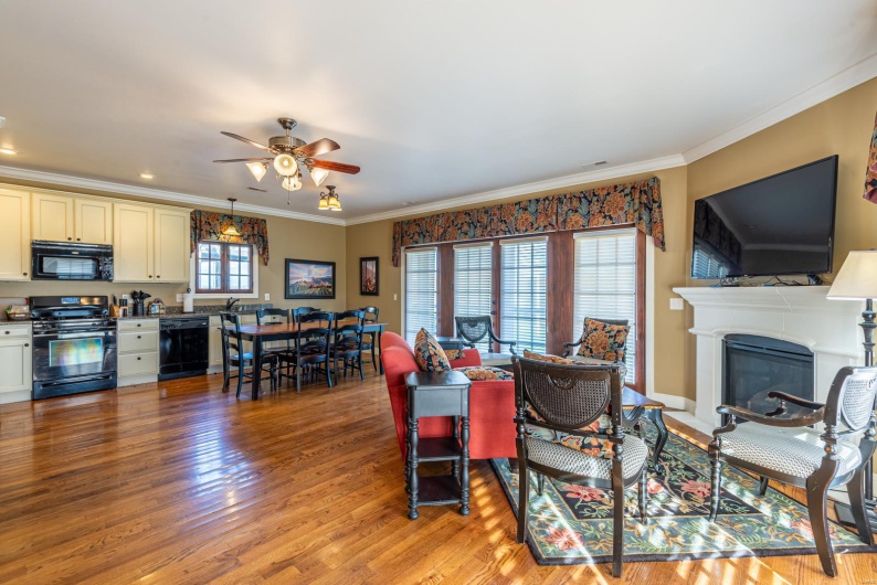 Living room featuring ceiling fan, ornamental molding, and light hardwood / wood-style flooring
