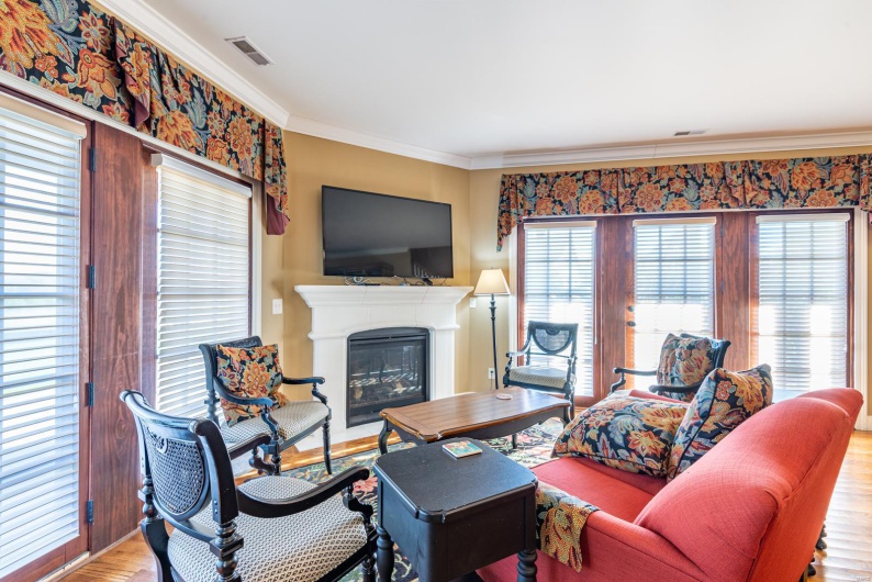 Living room with ornamental molding and light hardwood / wood-style flooring