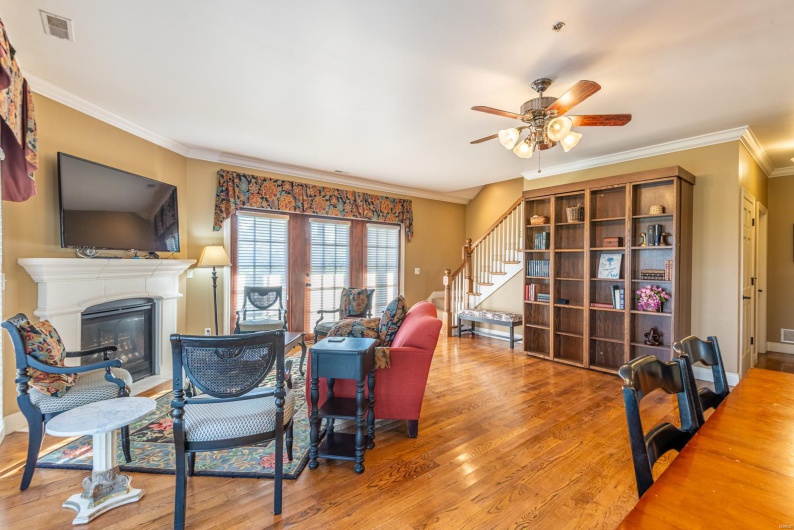 Living room featuring ceiling fan, wood-type flooring, and crown molding