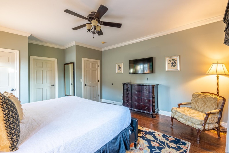 Bedroom featuring dark hardwood / wood-style floors, ceiling fan, and ornamental molding