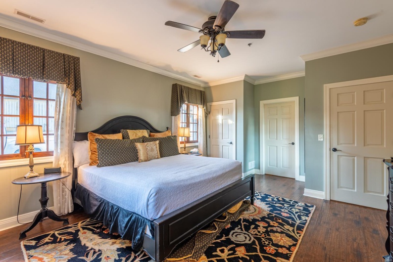 Bedroom with multiple windows, ceiling fan, dark wood-type flooring, and ornamental molding