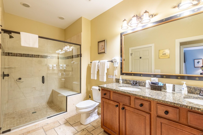Bathroom featuring vanity, an enclosed shower, and toilet