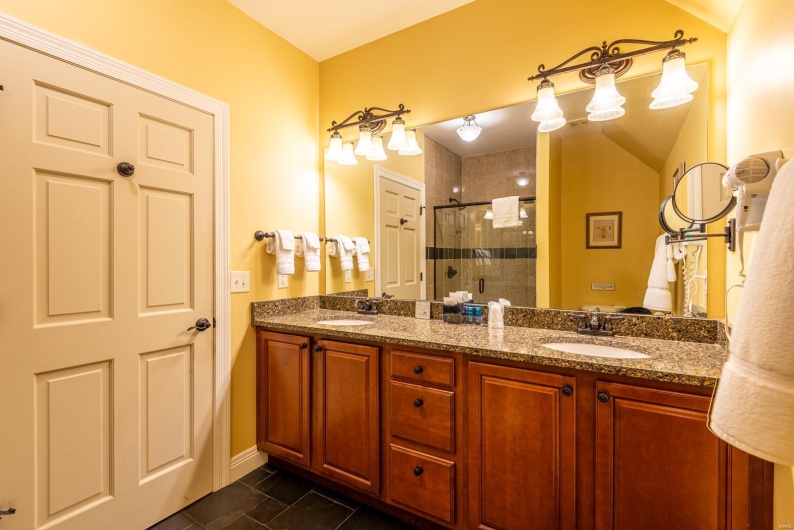Bathroom with tile patterned flooring, vanity, and a shower with door