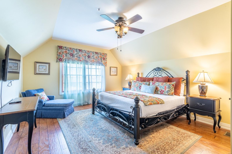 Bedroom with ceiling fan, hardwood / wood-style floors, and lofted ceiling