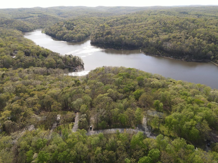 Aerial view featuring a view of trees and a water view