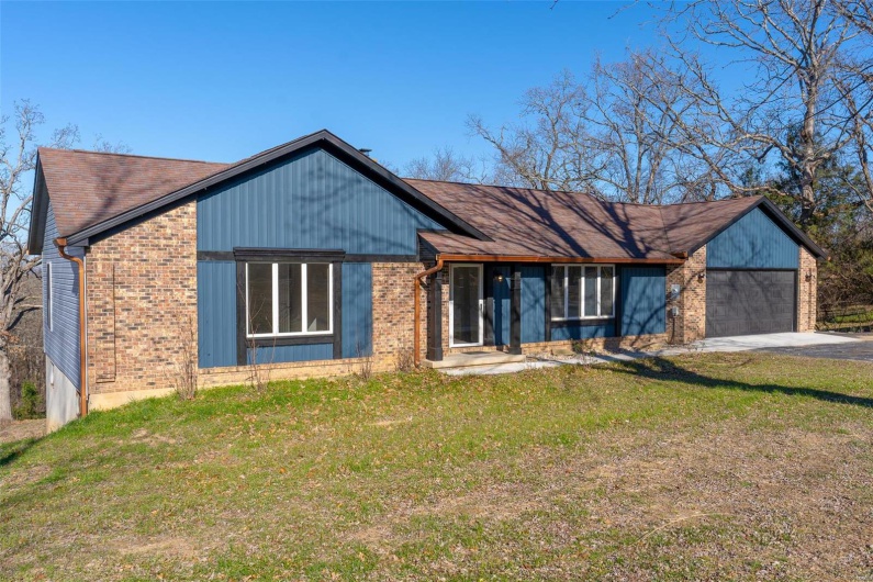 View of front facade with a garage and a front lawn