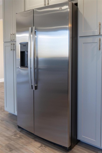 Kitchen with stainless steel fridge and  wood-style flooring