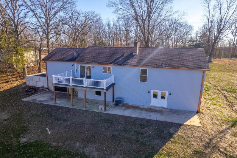 Rear view of property featuring a patio, central AC unit, a lawn, and a wooden deck