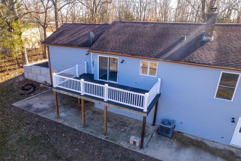 Back of house with a deck and central AC unit