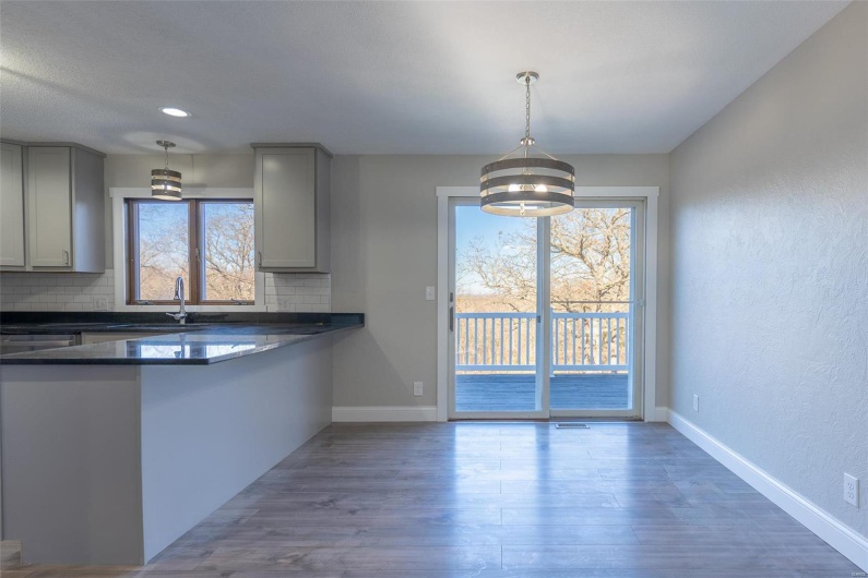 Kitchen with backsplash, gray cabinets, a chandelier, and decorative light fixtures