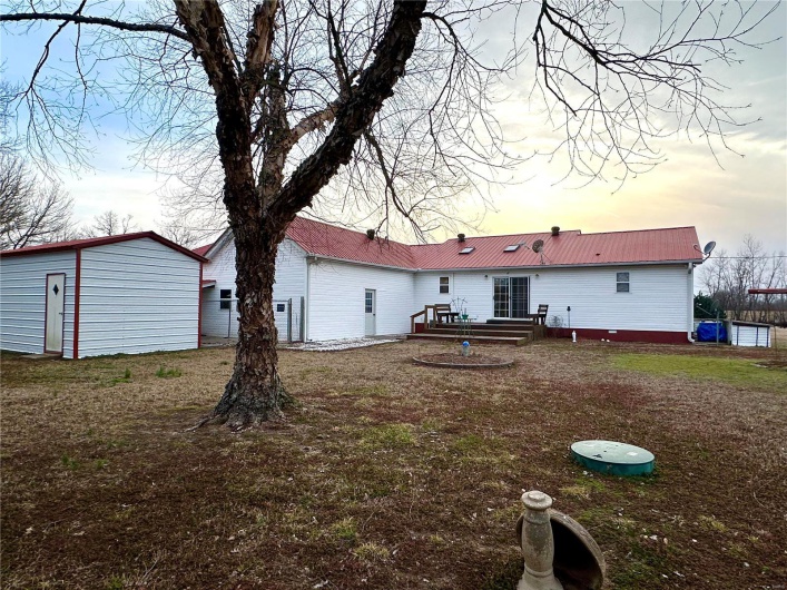 Back of house with metal roof and a deck