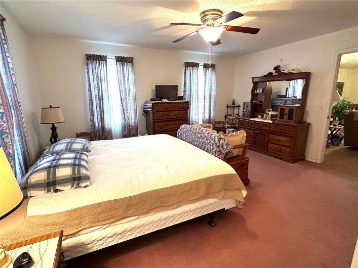 Bedroom with light carpet and a ceiling fan