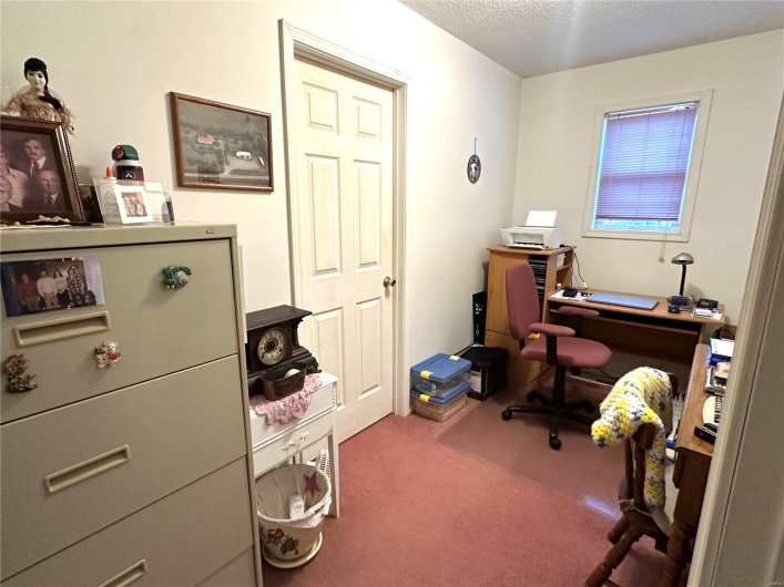 Carpeted office space with a textured ceiling