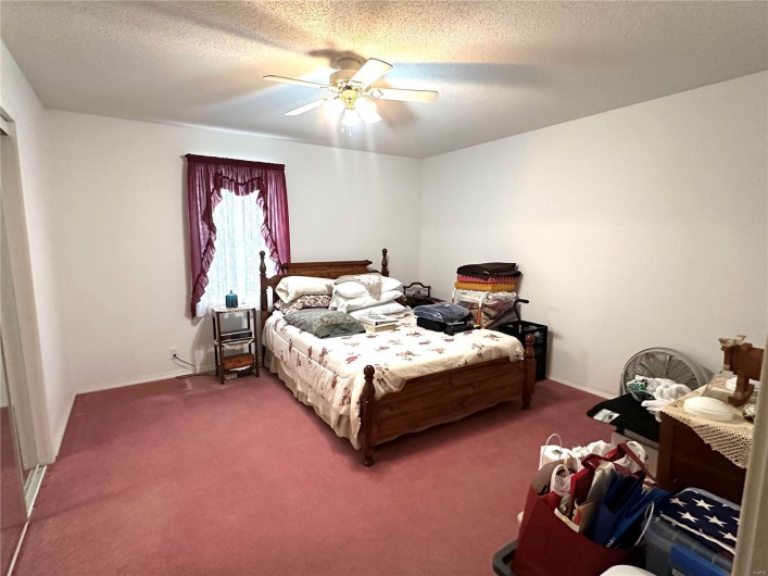 Bedroom featuring a textured ceiling, carpet floors, a ceiling fan, and baseboards