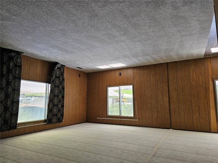 Unfurnished room with carpet and wood walls
