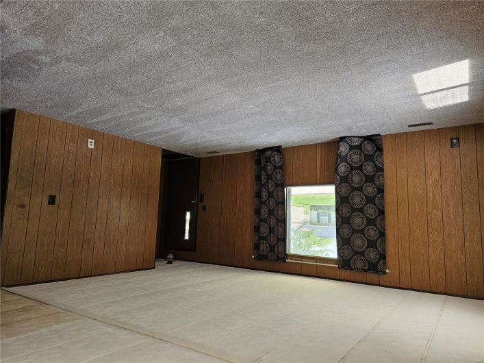 Unfurnished room with carpet floors and wood walls
