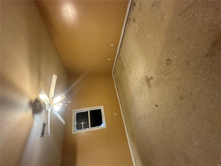 Carpeted empty room featuring a textured ceiling, visible vents, a ceiling fan, and baseboards